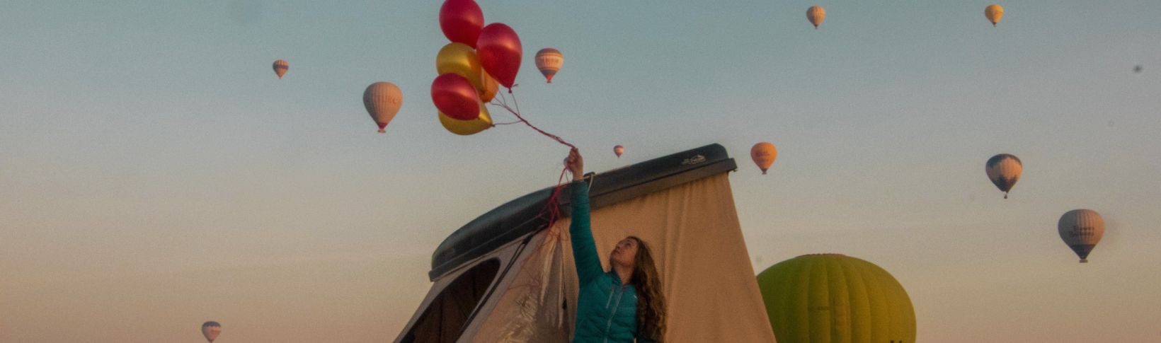 personne avec des ballons devant sa tente naitup