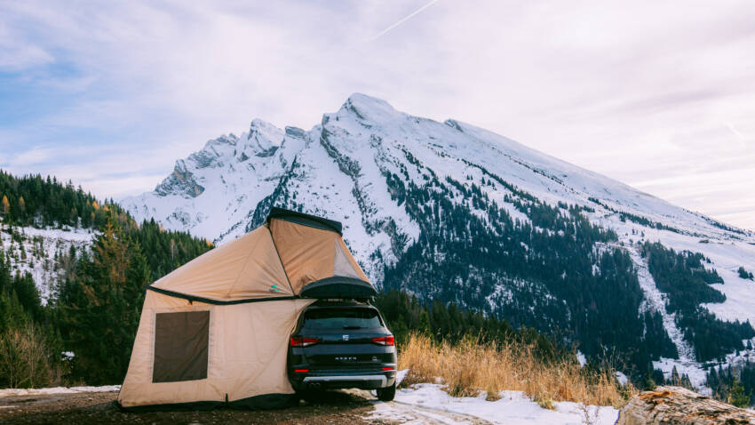 Tente de toit TrïUp Legend NaïtUp installée sur SUV, avec annexe, en bivouac d’hiver face aux montagnes enneigées